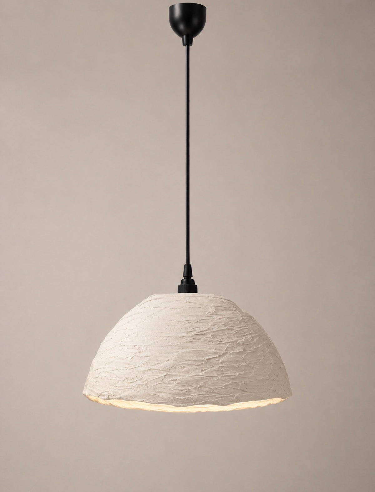 A modern pendant light with a textured, dome-shaped off-white shade and a matte black suspension rod and canopy, shown against a solid warm beige background.