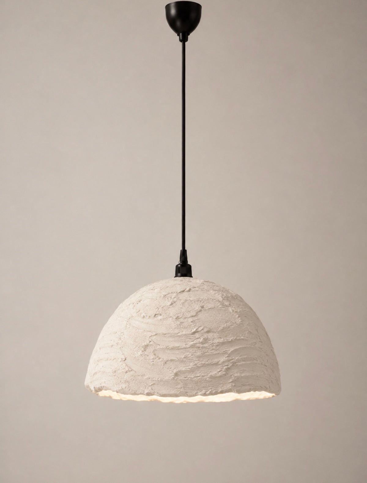A modern pendant light with a textured, organic-shaped white shade and a black hanging rod and canopy, shown against a neutral beige background.