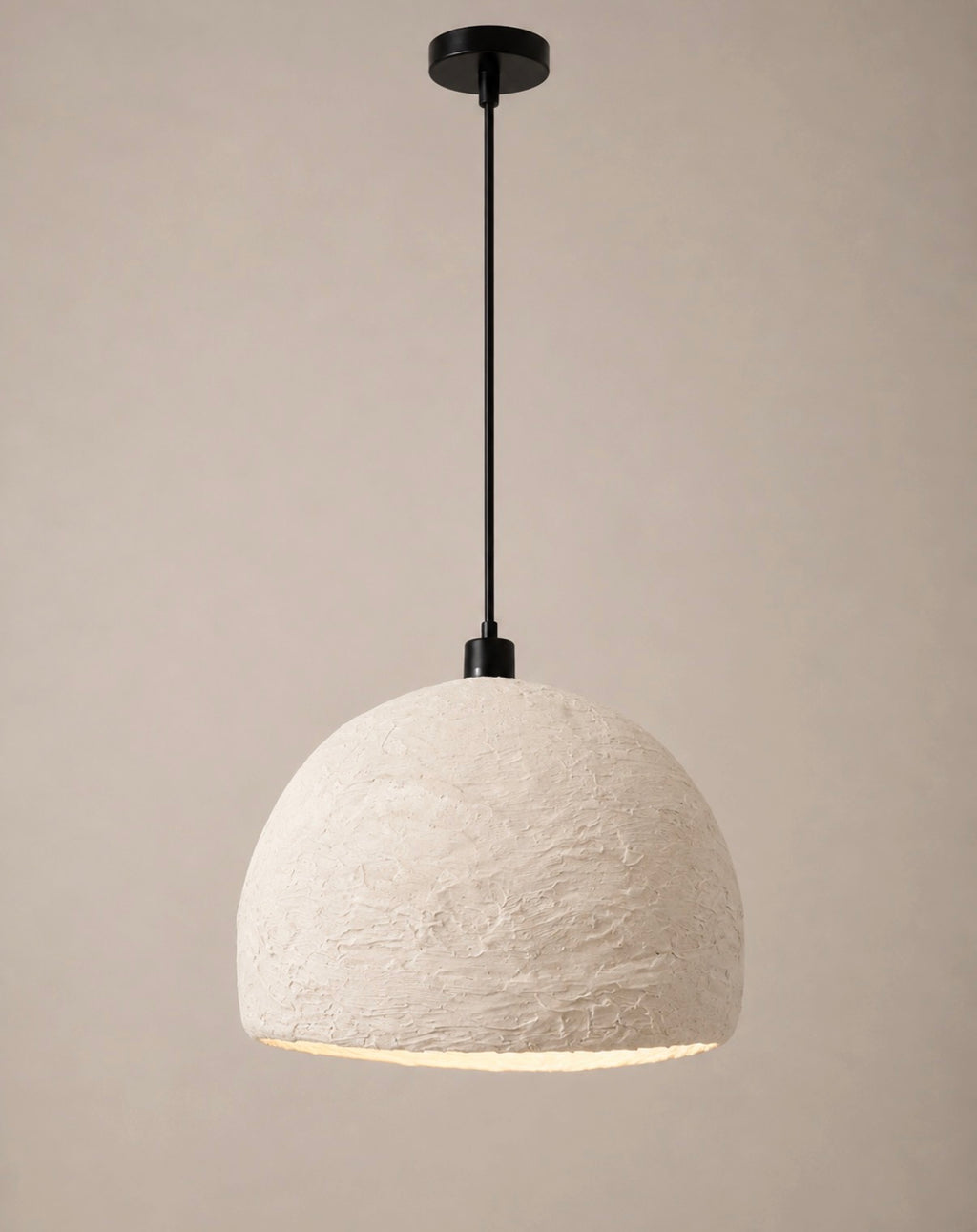 A modern pendant light with a textured off-white dome shade and a matte black suspension rod and canopy, shown against a plain beige background.